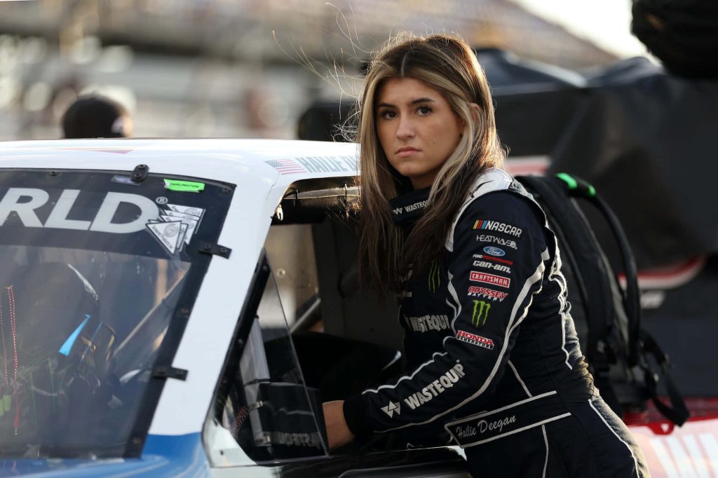 Hailie Deegan NASCAR driver in black racing suit trackside with her car motorsports wallpaper