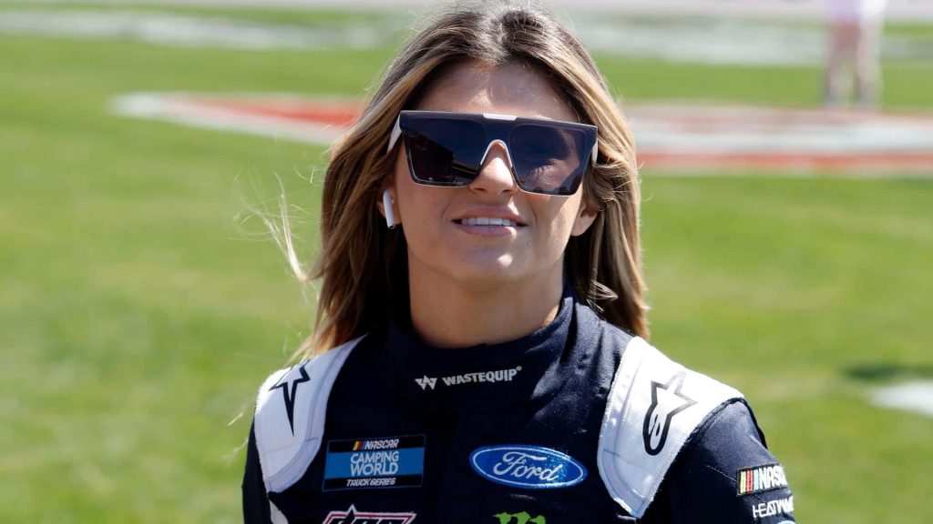 NASCAR racer Hailie Deegan in Ford racing suit and sunglasses vibrant outdoor portrait wallpaper