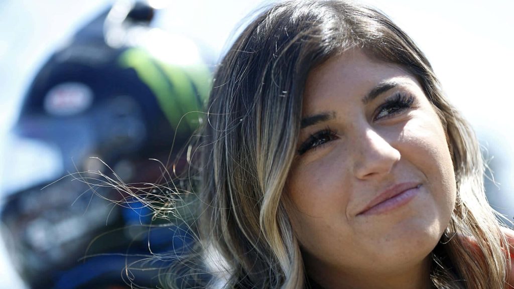 Portrait of professional race car driver Hailie Deegan in natural light with racing helmet background Wallpaper