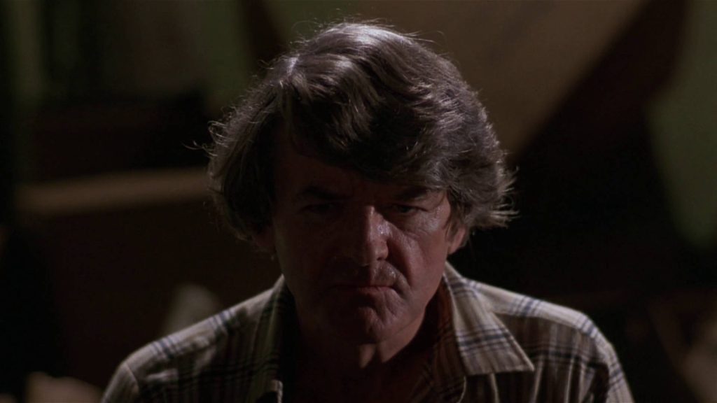 Cinematic close-up of Hal Holbrook with shaggy hair and plaid shirt in dramatic low light Wallpaper