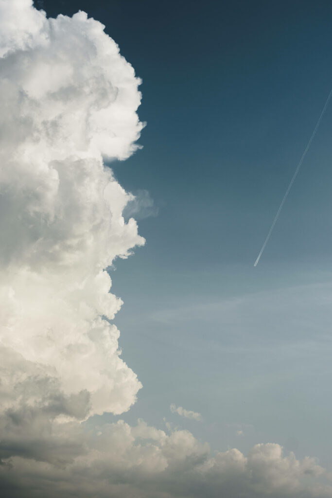 Split Perspectives: Captivating Cloudscape and Mysterious Object against Azure Sky - iPhone Wallpaper