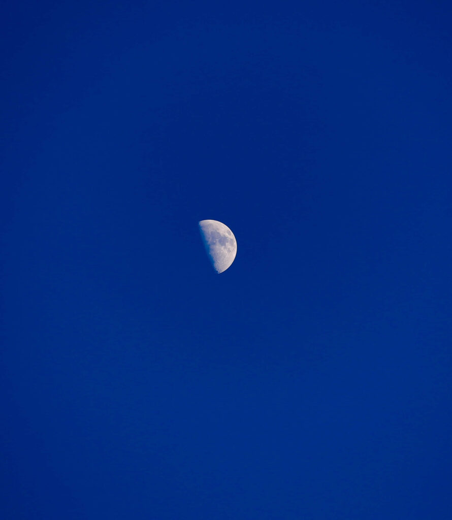 Half Moon Glow: Vibrant Deep Blue Sky Wallpaper Background