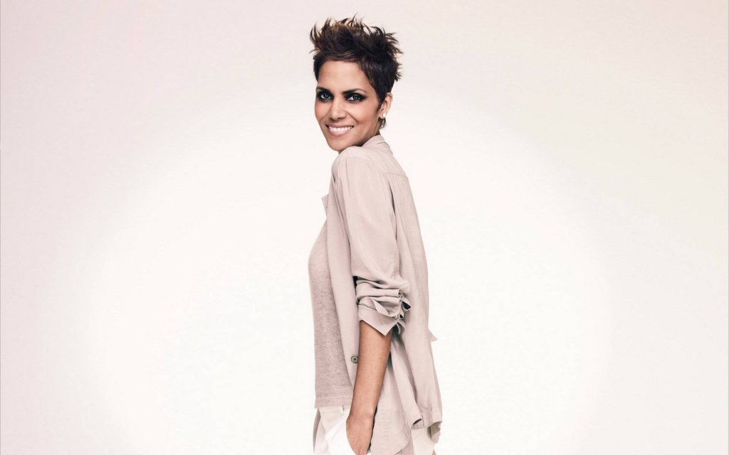 Halle Berry studio portrait with short pixie cut and dramatic eyeliner in beige outfit smiling Wallpaper