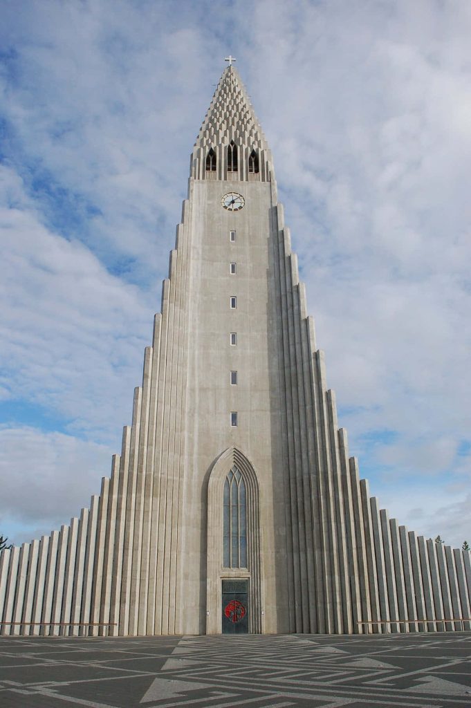 Hallgrímskirkja church phone wallpaper with symmetrical concrete tower and cloudy sky background
