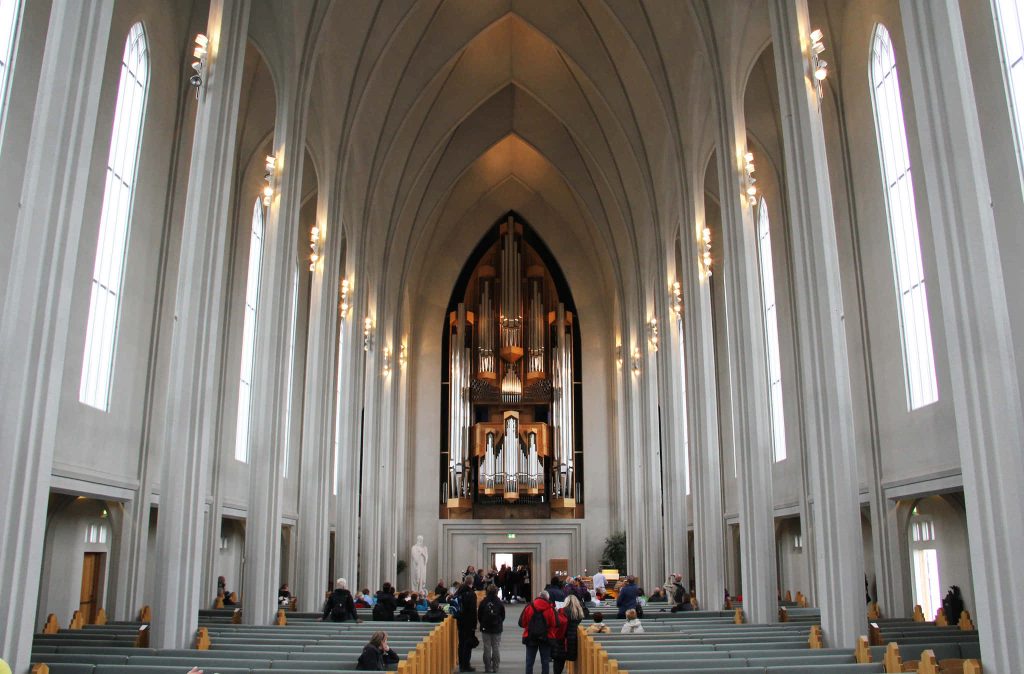 Interior of Hallgrímskirkja Church Reykjavik with towering columns majestic pipe organ and natural light Wallpaper