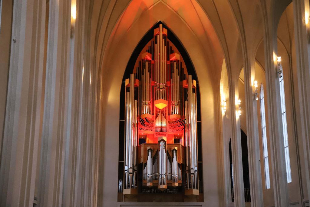 Hallgrimskirkja Church pipe organ in Reykjavik Iceland glowing warm red under soaring arches Wallpaper