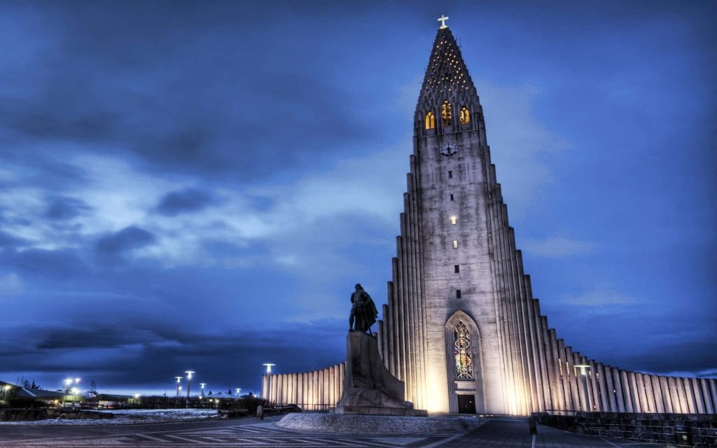 Hallgrímskirkja church and Leif Erikson statue in Reykjavík under moody twilight sky wallpaper