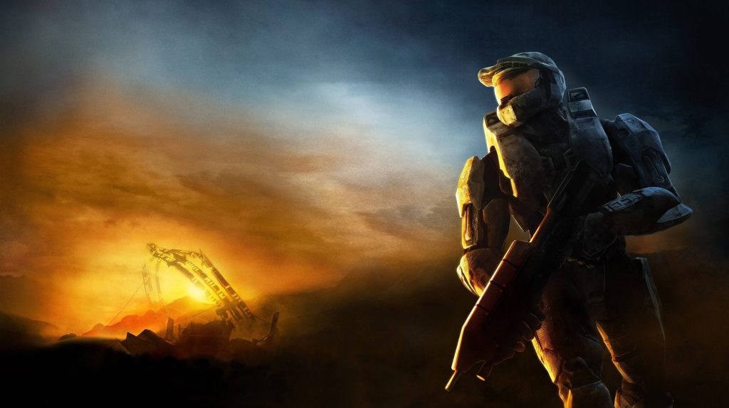 Master Chief in MJOLNIR armor gazing at sunset over a dramatic Halo 3 battlefield landscape Wallpaper