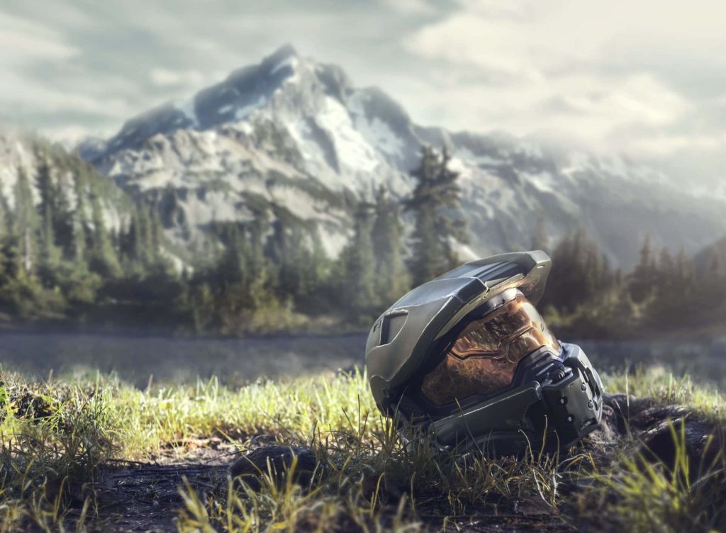 Halo Infinite wallpaper Master Chief Mjolnir helmet in grassy field with snow-capped mountains background