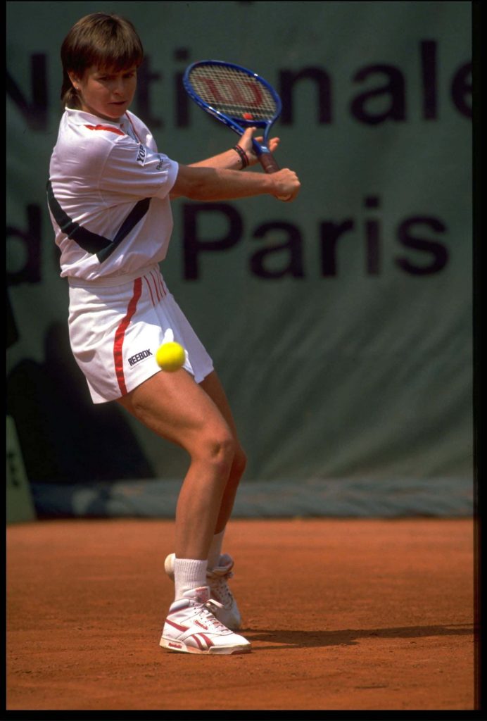Hana Mandlikova tennis player mid-swing on red clay court wearing Reebok intense focus wallpaper