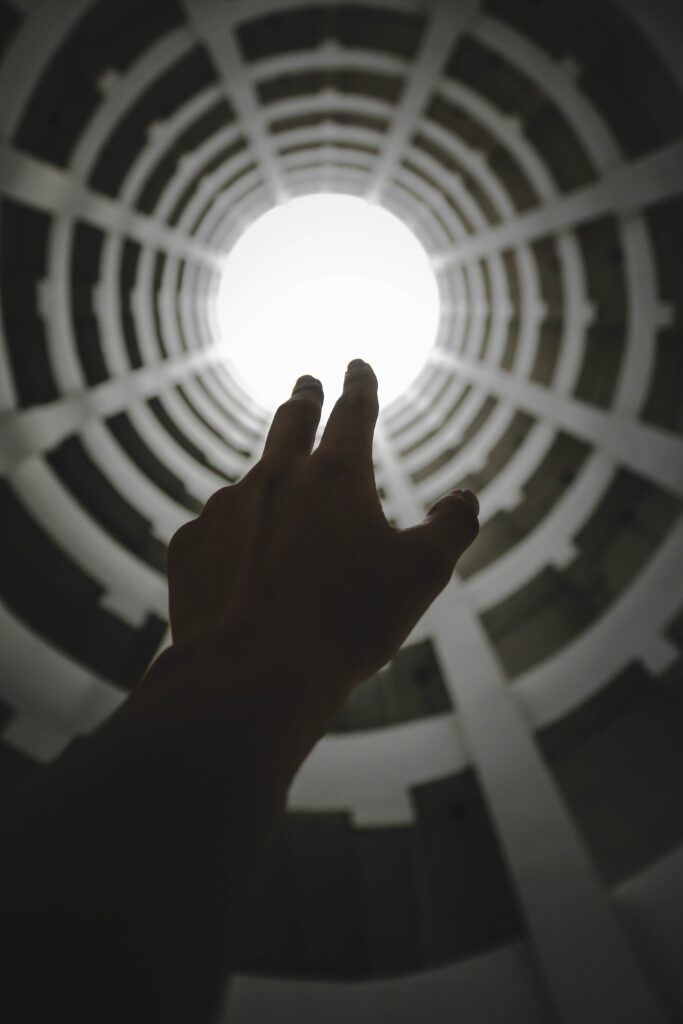 Captivating Wallpaper: Hand Reaching for Light in Spiral Tunnel
