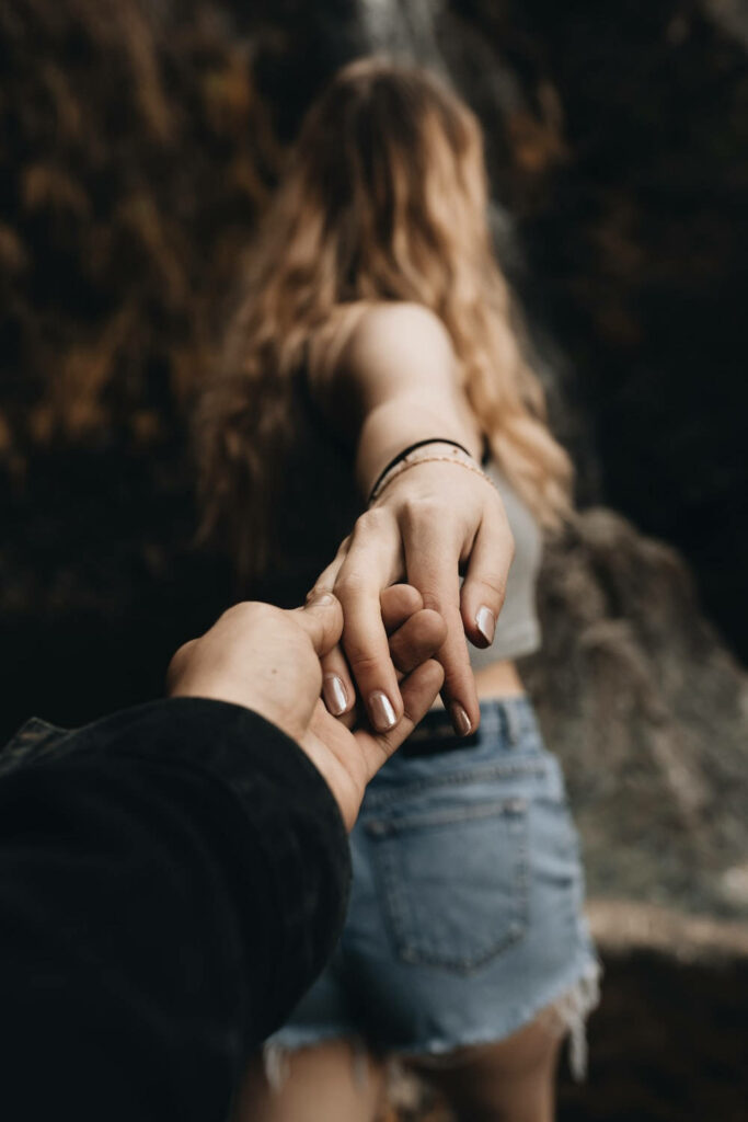 Blurred Background: A Tender Embrace as She Leads, Hand in Hand Wallpaper