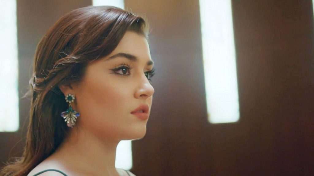 Hande Erçel side profile wallpaper with natural makeup winged eyeliner and colorful earrings