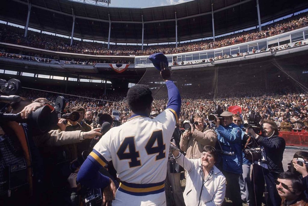 Hank Aaron number 44 raising cap in packed stadium iconic baseball moment wallpaper background