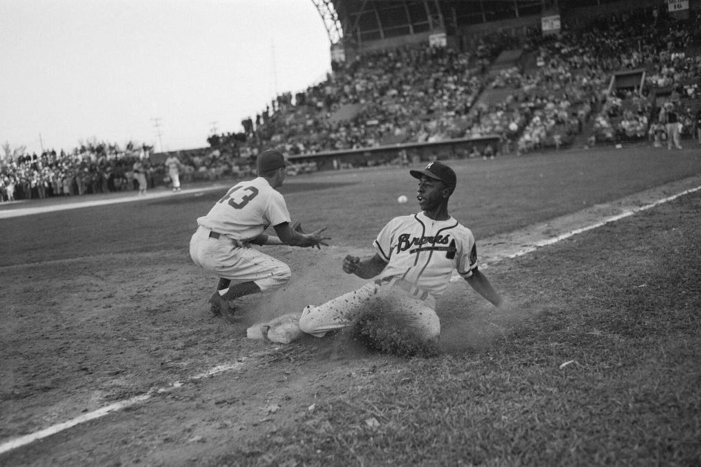 Hank Aaron sliding into home plate in vintage Milwaukee Braves uniform black and white photo Wallpaper