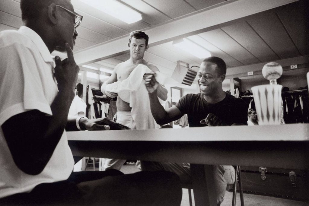 Hank Aaron laughing with Eddie Mathews in vintage black and white baseball locker room photo wallpaper
