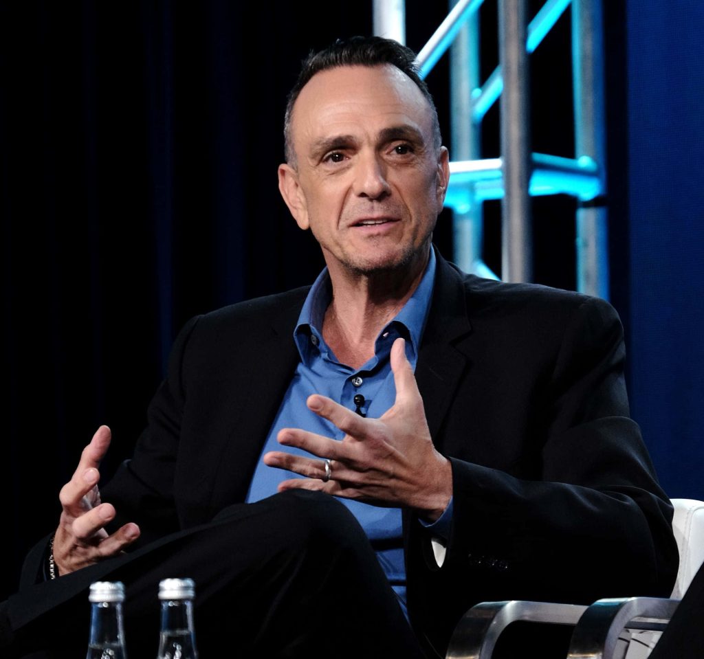 Hank Azaria in black blazer and blue shirt mid-gesture modern blue-lit studio portrait wallpaper