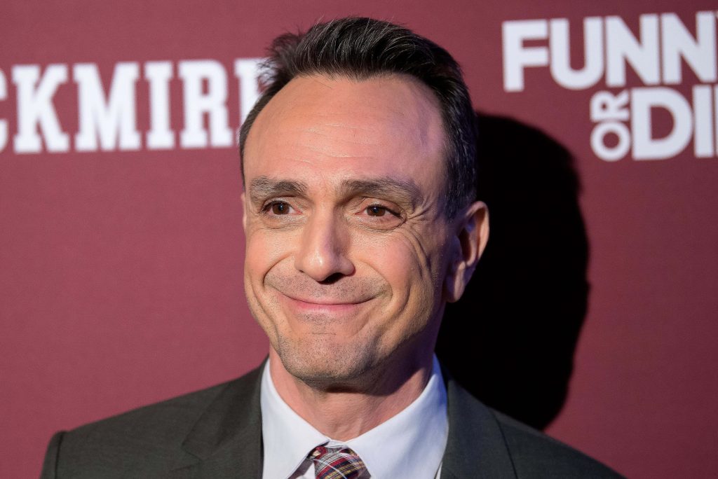 Hank Azaria in sharp suit with subtle smile at Funny or Die event burgundy backdrop portrait Wallpaper