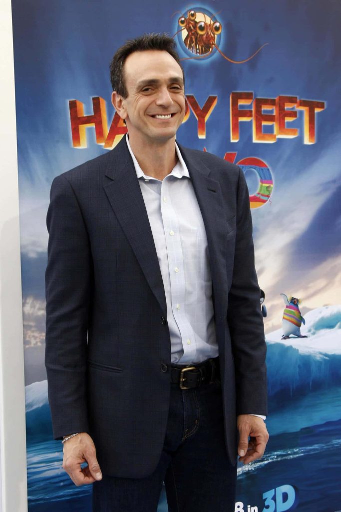 Hank Azaria in dark blazer at Happy Feet Two event with icy blue movie backdrop wallpaper