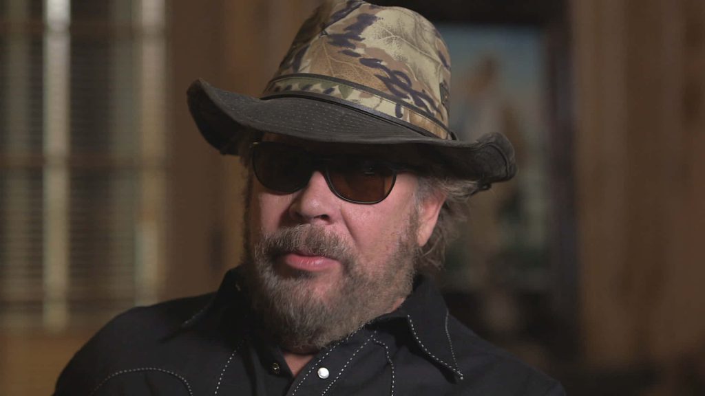 Hank Williams Jr country music portrait wearing camouflage hat dark sunglasses black western shirt Wallpaper