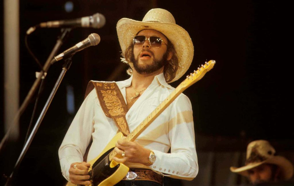 Hank Williams Jr live concert photo wearing straw cowboy hat playing yellow electric guitar wallpaper