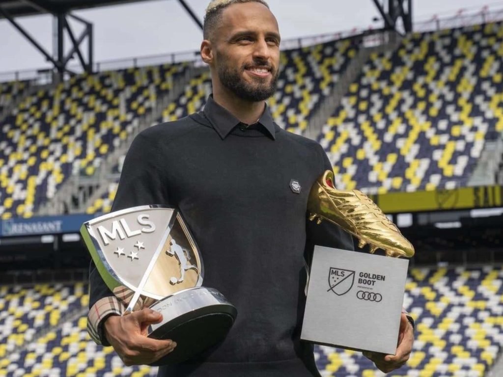 Hany Mukhtar smiling with 2022 MLS MVP and Golden Boot trophies in stadium wallpaper