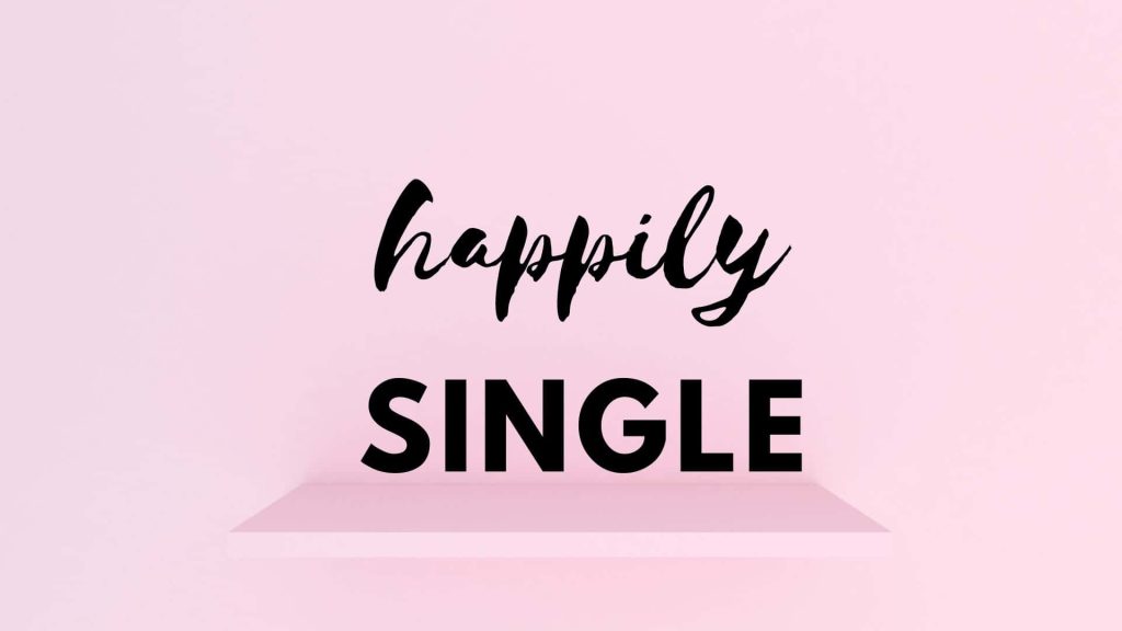 Minimalist happily single wallpaper with black cursive and bold text on pastel pink background