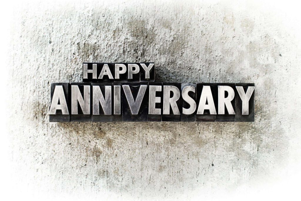 Happy Anniversary wallpaper with bold metallic 3D letters on textured light grey concrete wall