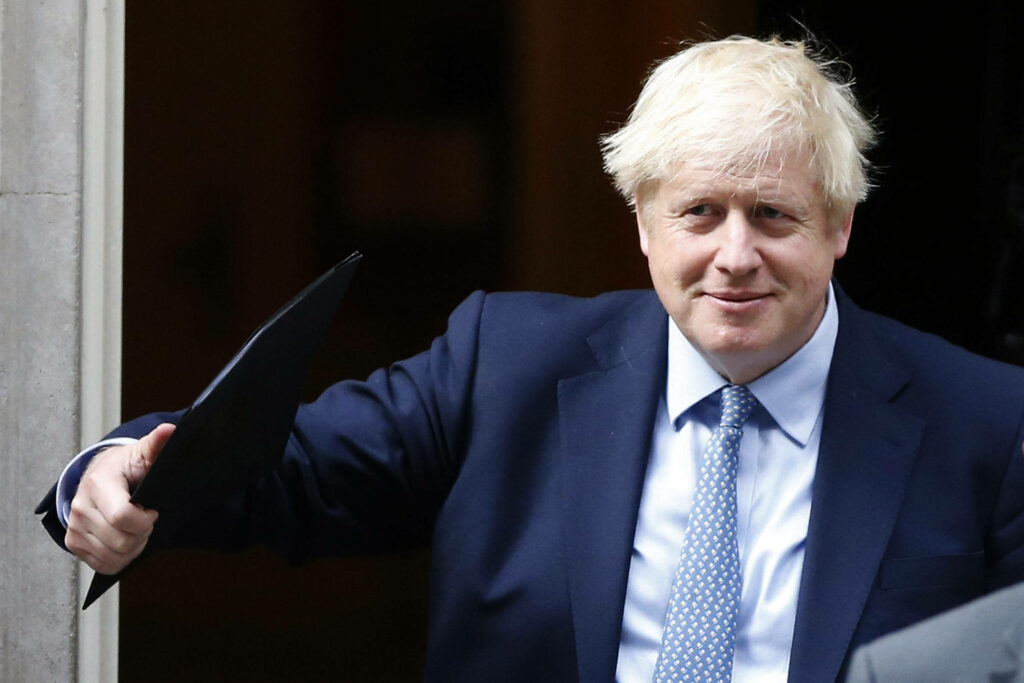 Happy Boris Johnson smiling in navy suit and polka dot tie outdoor professional portrait wallpaper