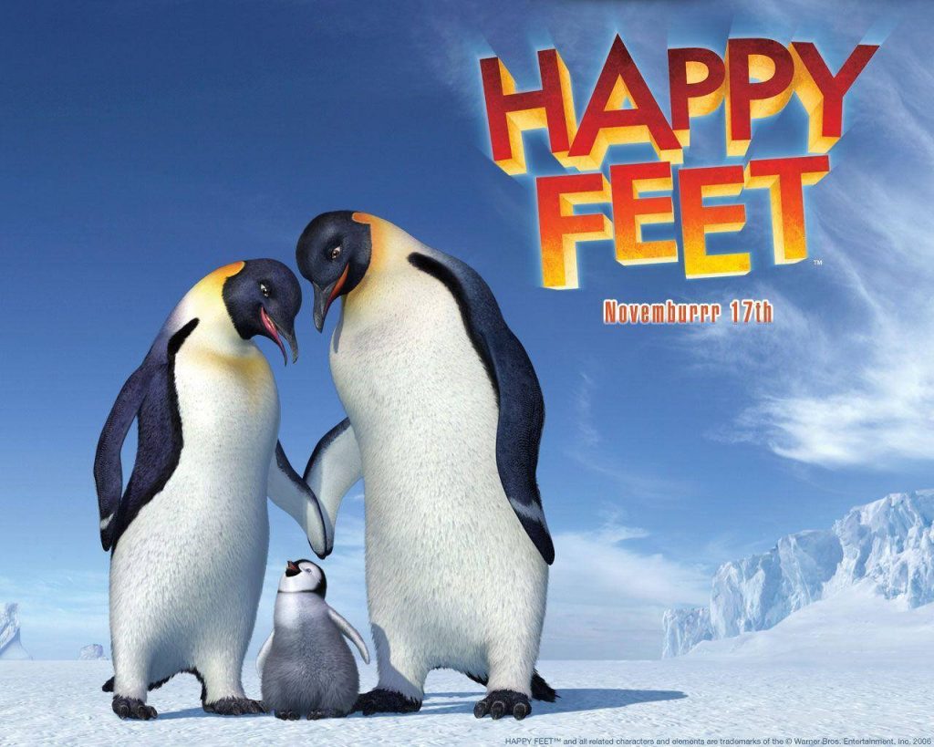 Happy Feet wallpaper with CGI emperor penguin family on icy Antarctic landscape under blue sky