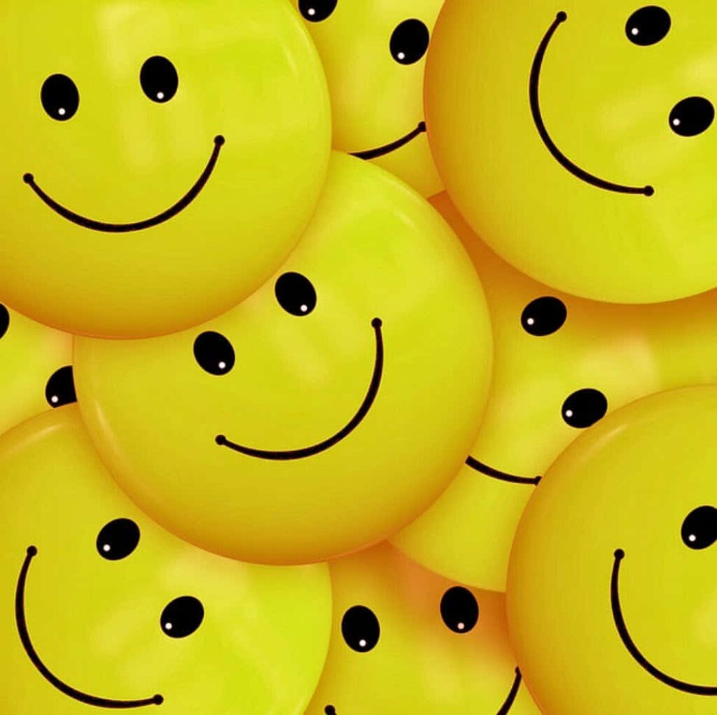 Yellow Happy Smile: A Stylish and Adorable Symbol on a White Background Wallpaper