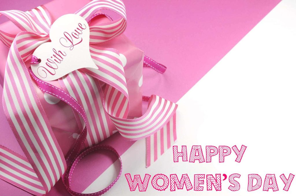 Happy Women’s Day wallpaper with pink polka-dot gift box and striped ribbon on pink background