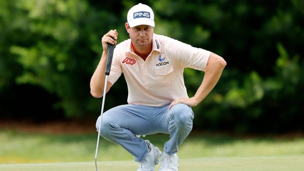 Harris English focused reading golf putt on lush green course wearing PING cap and polo Wallpaper