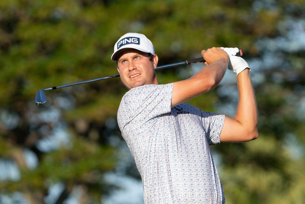 Professional golfer Harris English focused mid-swing in white PING cap and patterned polo Wallpaper