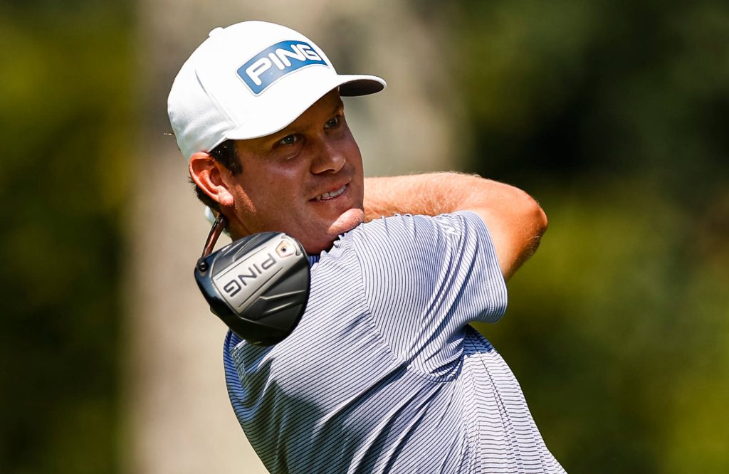 Harris English mid-swing smiling wearing white Ping cap grey striped shirt green golf course Wallpaper