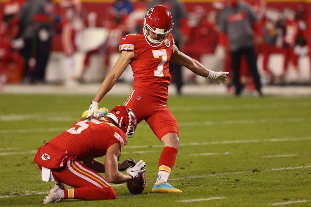 Kansas City Chiefs kicker Harrison Butker mid field goal kick with holder NFL action wallpaper