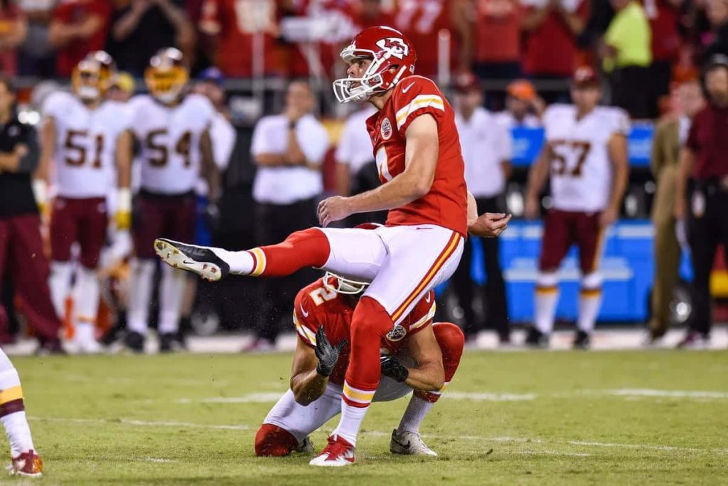 Kansas City Chiefs kicker Harrison Butker kicking a field goal in red white uniform NFL action wallpaper
