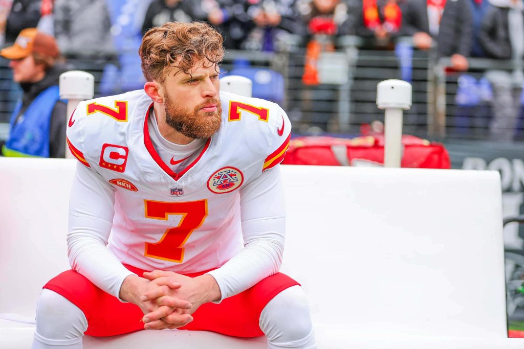 Kansas City Chiefs kicker Harrison Butker in white jersey sitting focused on bench game day wallpaper