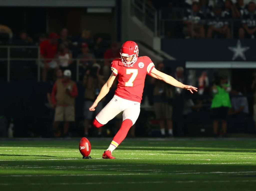 Harrison Butker NFL kicker in Chiefs jersey number 7 powerful kick high-contrast football wallpaper