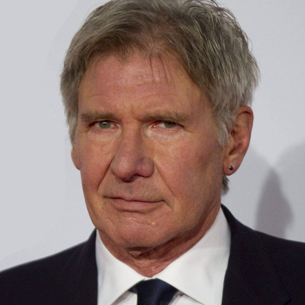 High-resolution portrait of Harrison Ford in suit and tie with chin scar and ear stud background Wallpaper