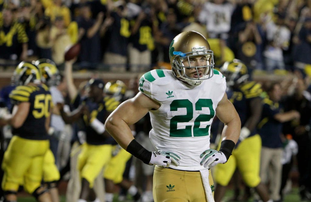 Harrison Smith Notre Dame football player in gold white jersey focused stadium background wallpaper