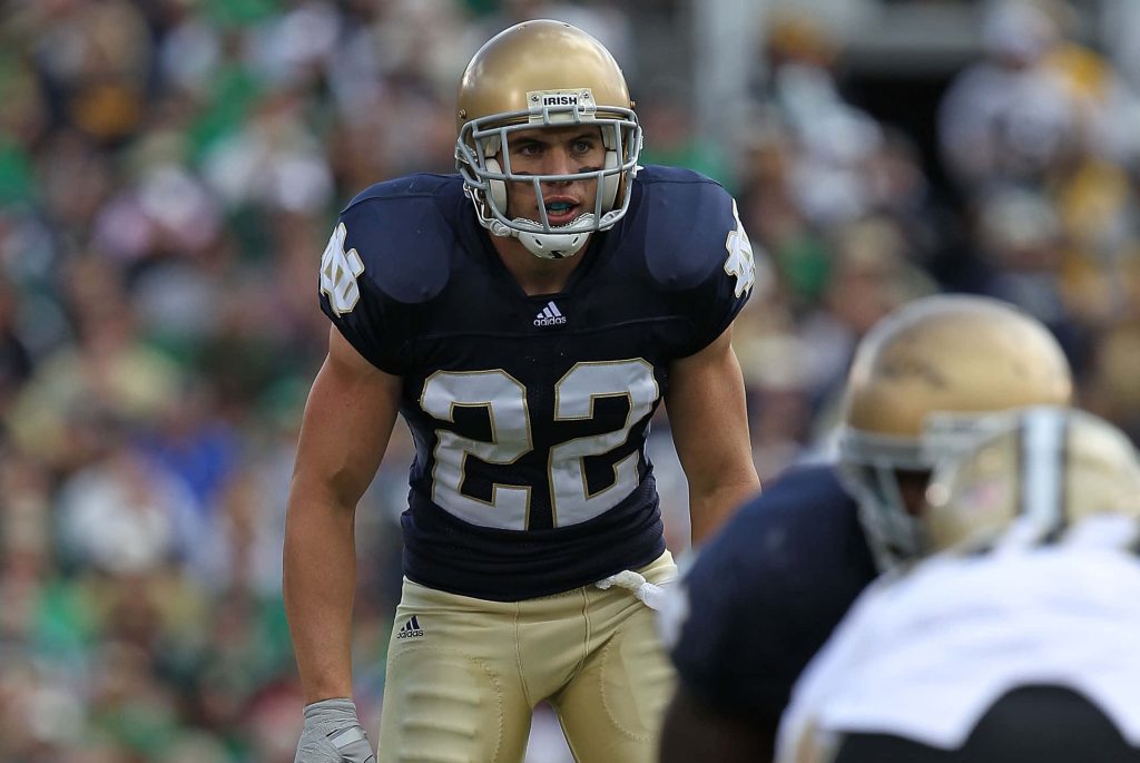 Harrison Smith Notre Dame football player in number 22 jersey and gold helmet on field Wallpaper