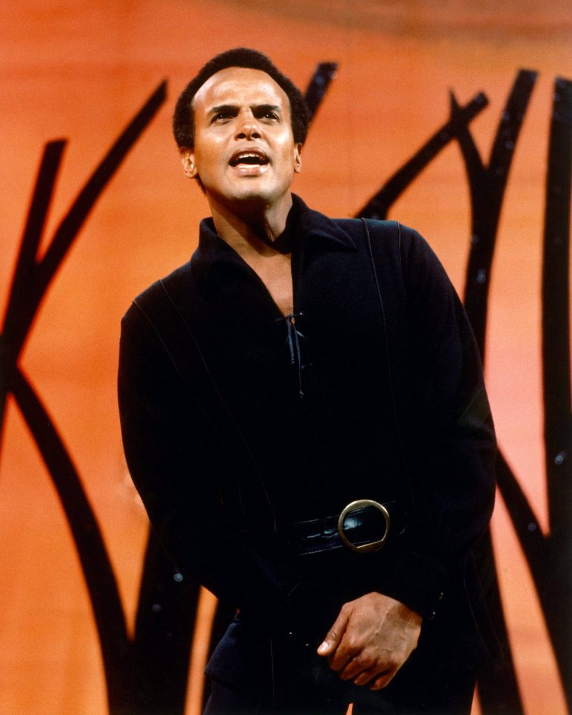 Harry Belafonte 1965 vintage stage photo in dark tunic vibrant orange backdrop black silhouettes Wallpaper