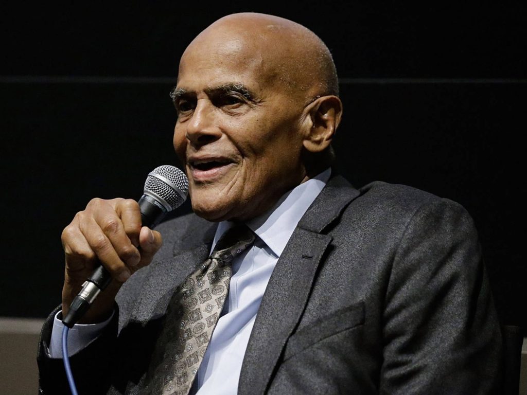 Harry Belafonte speaking into microphone in formal suit iconic social activist portrait wallpaper