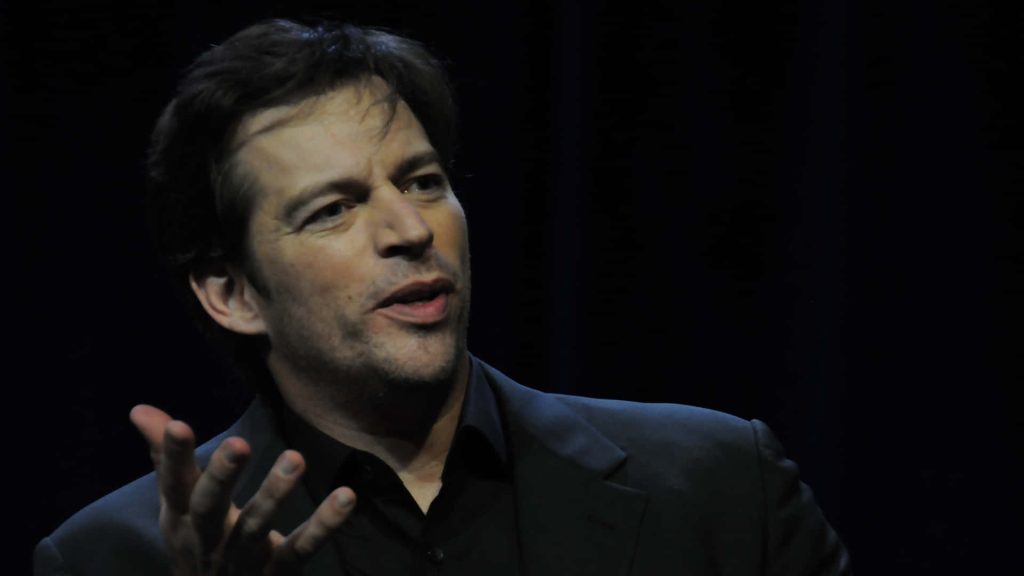 Harry Connick Jr. speaking on stage in dark suit with dramatic black background portrait wallpaper