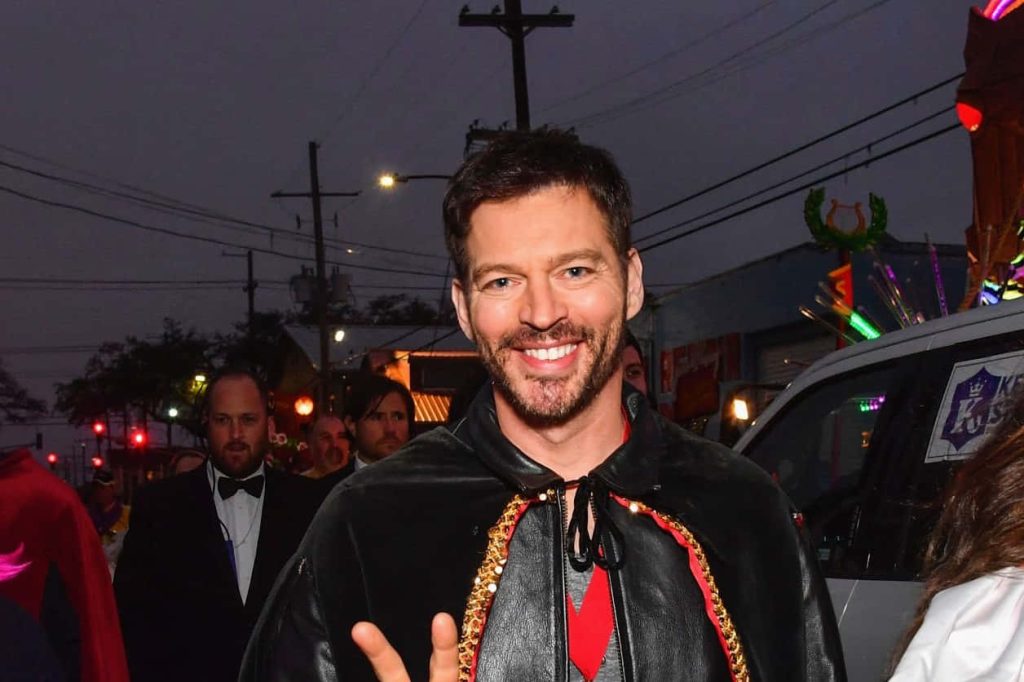 Harry Connick Jr smiling in black cape at festive outdoor evening parade wallpaper background