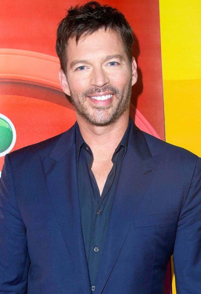 Harry Connick Jr. smiling in sharp navy suit bright red yellow background studio portrait wallpaper
