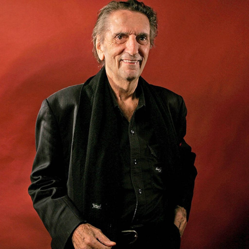 Harry Dean Stanton formal portrait deep rust red background black blazer scarf studio photo Wallpaper