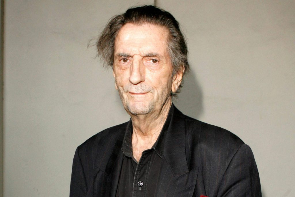 Portrait of iconic actor Harry Dean Stanton in black pinstriped blazer with warm smile wallpaper