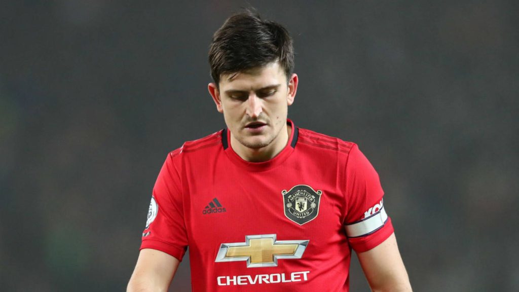 Harry Maguire in red Manchester United jersey focused on pitch intense football emotion wallpaper